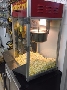 this is one of our Gold Medal popcorn machines with a red top we repaired at a customers location in the Minnesota inside the machine is a heap of popcorn that was just popped with the premeasured packet that you see.