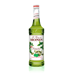 a glass bottle filled with a bright green syrup the white label has pistachio tree leaves and nuts flowing across the front