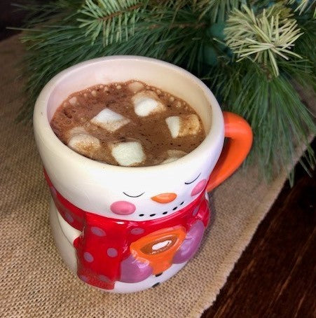 Rich, creamy hot chocolate / coco with little white marshmallows in a snowman cup that was dispensed from a cappuccino machine