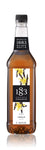 1883 Vanilla syrup has brown vanilla beans  entangled with bright yellow flowers and the label
