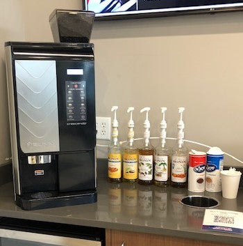 a 9 selection bean to cup bunn Crescendo coffee brewer with Monin syrups and other coffee condiments all on a countertop