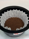 a black coffee brewer basket with a white coffee filter filled with a medium roasted Lakes Coffee House Blend