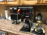 Bunn coffee brewer set up at an office with coffee pots and a grinder 