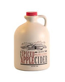 a 64 ounce light brown jug of spiced apple cider with an old wooden covered bridege on the label 